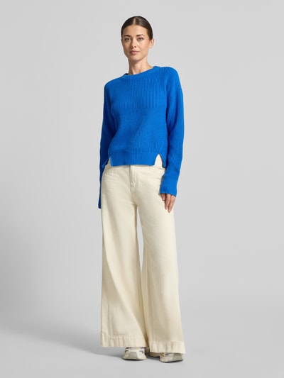 Frauenmodel trägt Slim Fit Pullover aus reiner Baumwolle von Jake*s Casual in Blau zu weiter Cremehose, Ganzkörperansicht von vorne.