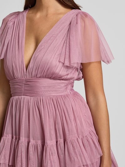 Kobiece model prezentuje Cocktailkleid mit tiefem V-Ausschnitt od LACE & BEADS, różowy tiul, A-linia, pasek w talii, stonowana tekstura, rozmiar S, szerokość w rozmiarze S: 35 cm, długość pleców: 84 cm, długość rękawa: 22 cm, detal górnej części sukienki, zbliżenie na górę.
