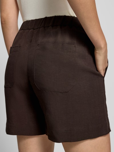Frauenmodel trägt Regular Fit Shorts aus Viskose-Mix Modell 'Melane' von OPUS, Leinen-Viskose-Mix, Teilelastischer Bund, Eingrifftaschen, Farbe Dunkelbraun, Ganzkörperansicht Rückansicht.