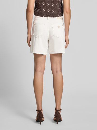 Vrouwenmodel draagt Wide Fit Shorts met Lyocell-Anteil in Denim-Optik van guess, wit, 5-pocketmodel, mix van katoen en lyocell, knoop- en ritssluiting, bandwijdte maat 27 is 39 cm, binnenbeenlengte 15 cm, denimlook, ganzlichaamsaanzicht achteraan.