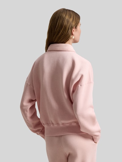 Frauenmodel trägt Sweatshirt mit Label-Stitching von Polo Ralph Lauren in Rosa, lockerer Schnitt, Polokragen, Ganzkörperansicht Rückansicht.