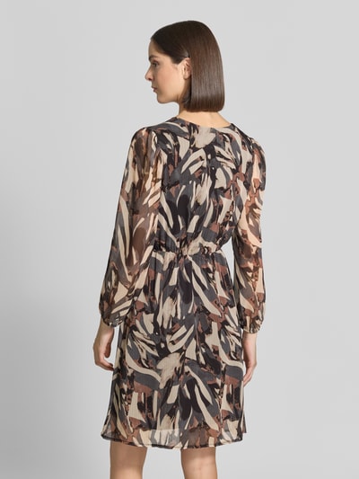 Frauenmodel trägt Minikleid mit V-Ausschnitt Modell 'Ev44aa' von ZABAIONE, abstraktes Muster in Braun- und Beigetönen, Ganzkörperansicht Rückansicht. Taillierter Schnitt, Chiffon, blickdichtes Unterkleid, elastische Ärmelabschlüsse, Rückenlänge bei Größe S 93 cm, Brustweite 45 cm, Ärmellänge 58 cm.