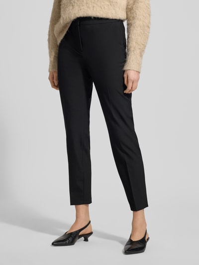 Frauenmodel trägt Regular Fit Schmale Hose mit Bügelfalten von s.Oliver BLACK LABEL, Optik: Unifarben, Mid Waist, Struktur, seitliche Eingrifftaschen, angedeutete Gesäßtaschen, elastischer Bund, Detailaufnahme Beine.
