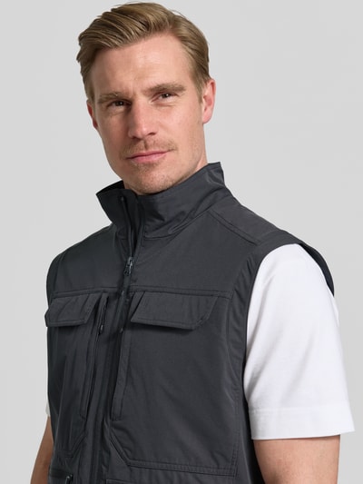 Männermodel trägt Regular fit bodywarmer met opgestikte zakken model 'Bergheim' van Icepeak, opstaande kraag, ritssluiting, steekzakken, ruglengte maat 50 67 cm, schouderbreedte 43 cm, borstwijdte 57 cm, donkergrijs, recht gesneden, textuur glad, Nahaufnahme Oberkörper.
