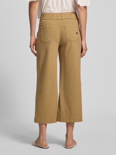 Männermodel trägt kuloty z mieszanki wiskozy i bawełny o kroju loose fit, model 'Martinique' od Buena Vista, długość wewnętrzna nogawki 64 cm, szerokość w rozmiarze S: 39 cm, wpuszczane kieszenie boczne, kieszenie z tyłu, zapięcie na guzik, mieszanka wiskozy i bawełny, kolor beżowy, tekstura gładka, tkanina matowa, Ganzkörperansicht Rückansicht.