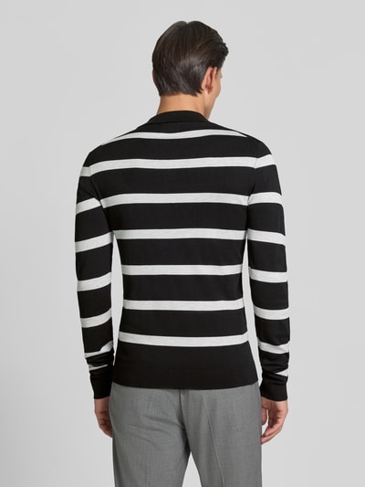 Männermodel trägt Strickpullover mit Polokragen Modell 'VERO' von MCNEAL, schwarz-weiß gestreift, Viskose-Mix, Ganzkörperansicht Rückansicht.