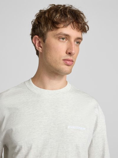 Männermodel trägt Oversized T-Shirt mit Label-Stitching von Pegador, Baumwoll-Mix, Rundhalsausschnitt, Nahaufnahme Oberkörper.