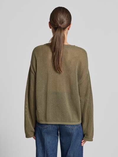 Frauenmodel trägt Loose Fit Pullover aus reiner Baumwolle Modell 'C_FARDE' von BOSS Orange in Olivgrün, grobe Strickstruktur, Ganzkörperansicht Rückansicht.
