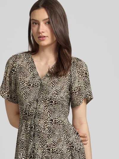 Frauenmodel trägt Minikleid aus reiner Viskose Modell 'EVIDA' von Only mit Allover-Muster, V-Ausschnitt, Taillengürtel, Nahaufnahme Oberkörper.