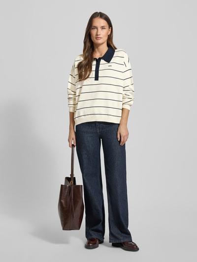 Frauenmodel trägt Sweter z dzianiny z mieszanki wiskozy, krój oversized, model 'taige' z kołnierzykiem polo, wyhaftowane logo, prążkowane wykończenia, długość tyłu 56 cm, rękawy 50 cm, Gestuz, Ganzkörperansicht von vorne.
