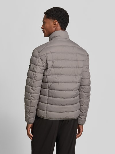 Männermodel trägt graue Regular Fit Steppjacke mit Zweiwege-Reißverschluss von Marc O'Polo, gesteppte Textur, Ganzkörperansicht Rückansicht.