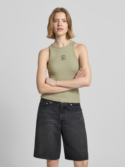 Frauenmodel trägt Tanktop mit Rundhalsausschnitt von REVIEW aus Baumwoll-Elasthan-Mix in Feinripp, eng anliegende Passform, Nahaufnahme Oberkörper.