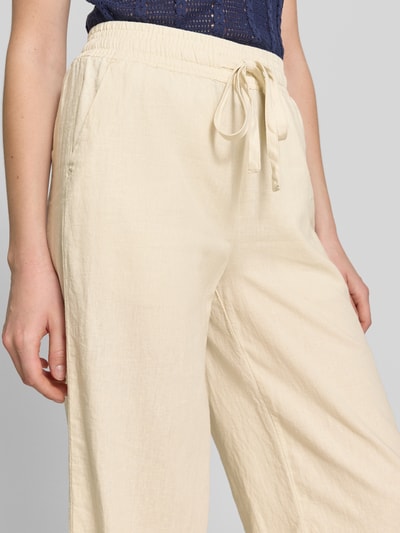 Frauenmodel trägt Wide Fit Stoffhose aus Leinen-Mix mit Viskose-Anteil Modell 'Ina' von Soyaconcept, cremefarben, Nahaufnahme Oberkörper. Damenhose mit elastischem Bund, Tunnelzug, verkürzter Passform, Bundweite 34 cm bei Größe S, Innenbeinlänge 63 cm bei Größe S, feine Stoffstruktur.