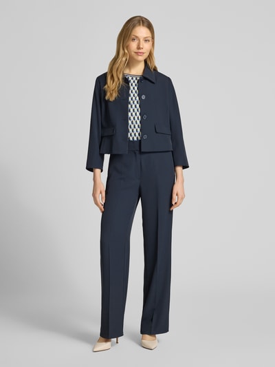 Frauenmodel trägt Regular Fit Blazer mit Umlegekragen von Betty Barclay im Dunkelblau, Elastischer-Material-Mix, Pattentaschen, durchgängige Knopfleiste, taillierte Passform, Rückenlänge bei Größe 36: 49 cm, Brustweite 47 cm, Ärmellänge 52 cm, Ganzkörperansicht von vorne.