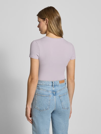 Frauenmodel trägt Slim Fit T-Shirt mit Logo-Stitching Modell 'Downtown' von Review, elastischer Baumwoll-Mix, Ganzkörperansicht Rückansicht.