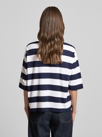Frauenmodel trägt Relaxed Fit Sweatshirt aus Viskose-Mix mit Brusttasche von monari, Halbarm, Rundhalsausschnitt, Logo-Stitching, navy-weiße Querstreifen, strukturierte Oberfläche, Ganzkörperansicht Rückansicht.