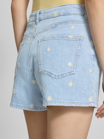 Frauenmodel trägt Regular Fit Jeansshorts aus Baumwoll-Mix Modell 'JOSEPHINE' von Only in hellblauer Denim-Optik mit Motiv-Stitching, 5-Pocket-Design, Gürtelschlaufen, Knopf und verdecktem Reißverschluss, Materialverarbeitung Twill, Nahaufnahme Rückansicht.