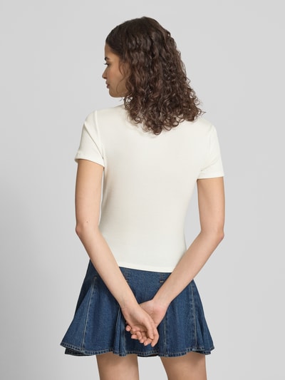 Frauenmodel trägt Slim Fit T-Shirt mit Herz-Stickerei Modell 'ELVA JUNE' von Only, unifarben, Rippstruktur, Ganzkörperansicht Rückansicht.