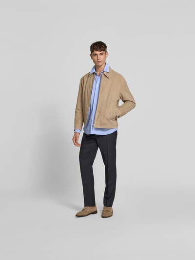 Männermodel trägt Slim Fit Anzughose aus Woll-Mix von Filippa K, Dunkelblau, Eingriff- und Gesäßtaschen, Bundfalten, Ganzkörperansicht von vorne.