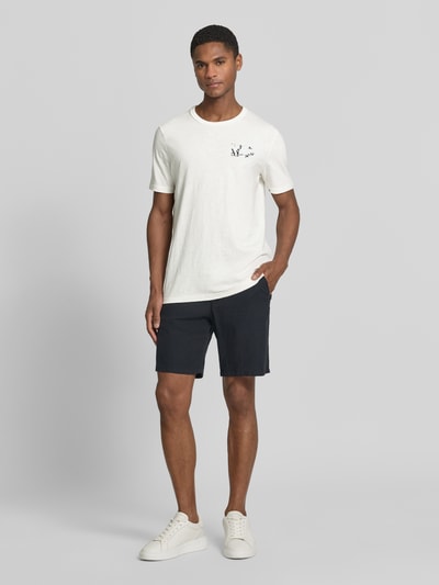 Mężczyzna model nosi Regular Fit T-Shirt aus reiner Baumwolle von s.Oliver RED LABEL, kolor jednolity, krój regular fit, krótki rękaw, bawełna, motyw nadruku, widok całej sylwetki z przodu.