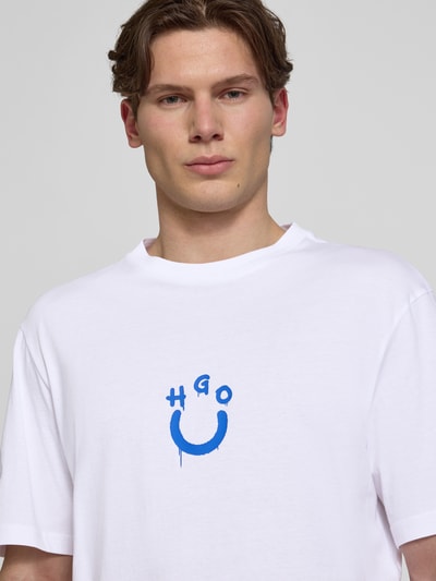 Männermodel trägt Regular Fit T-Shirt aus reiner Baumwolle Modell 'NORIZOM' von Hugo Blue, Optik: Unifarben, Logo-Print, Nahaufnahme Oberkörper.