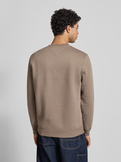 Männermodel trägt Regular Fit Sweatshirt aus mieszanka bawełny von Tommy Jeans, efekt: jednolity kolor, wyhaftowane logo, dzianina dresowa, długi rękaw, zakończenie rękawów i dół prążkowane, ganzkörperansicht rückansicht.