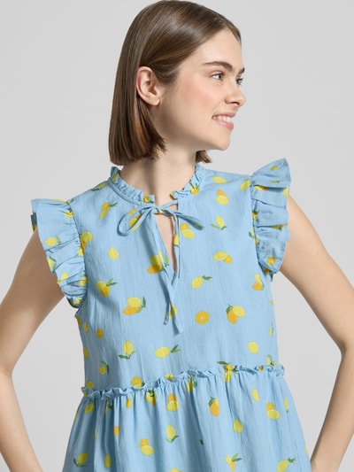 Frauenmodel trägt Regular Fit Schluppenbluse aus reiner Baumwolle Modell 'EMMA' von Pieces, Optik: Allover-Muster, Volant-Kragen, Schößchen, V-Ausschnitt mit Bindedetails, Ärmelform: ohne Ärmel, Ärmelabschluss: Volants, strukturierte Baumwoll-Textur, frische Farben, Ganzkörperansicht von vorne.