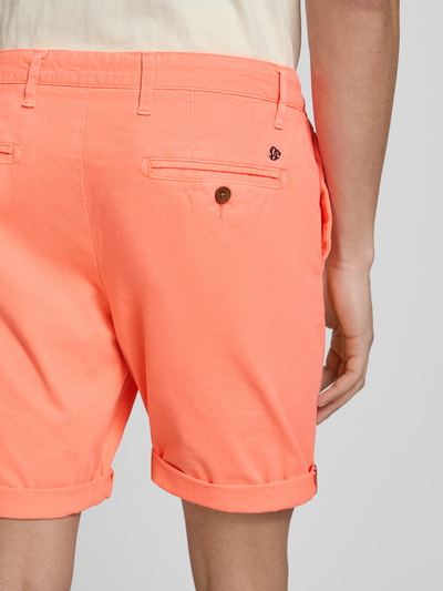 Männermodel trägt Regular Fit Shorts mit Münztasche von Superdry in Orange, Baumwoll-Mix, Gesäßtaschen, Nahaufnahme Rückansicht.