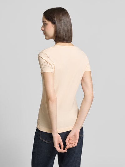 Frauenmodel trägt damski t-shirt z mieszanki bawełny i elastanu, dopasowany krój, model 'SCRIPT' od Guess, dekolt w łódkę, wyhaftowane logo, długość tyłu w rozmiarze S: 61 cm, całkowita sylwetka, widok z tyłu