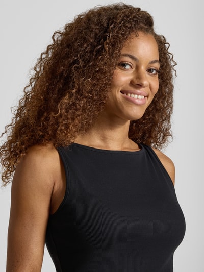 Frauenmodel trägt Slim Fit Tanktop aus Baumwoll-Mix Modell 'MAY' von PIECES, schwarz, Rippstruktur, unifarben, Nahaufnahme Oberkörper.