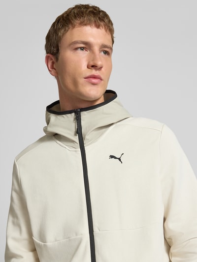 Männermodel trägt Sweatjacke mit Kapuze von PUMA PERFORMANCE aus Baumwoll-Mix, Label-Print, Reißverschluss, Nahaufnahme Oberkörper.