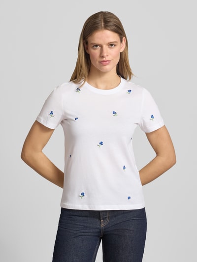 Vrouwenmodel draagt Regular Fit T-Shirt uit pure biologische katoen Modell 'KETTY LIFE' van Only, wit met geborduurde bloemen, unilook, ronde hals, korte mouw, voorkant bovenlichaam close-up.