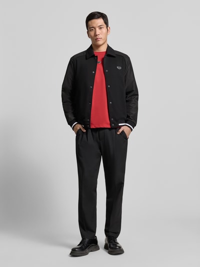 Männermodel trägt Jacke mit Label-Detail von Antony Morato, Regular Fit, Kentkragen, Schwarz, Eingrifftaschen, Ganzkörperansicht von vorne.