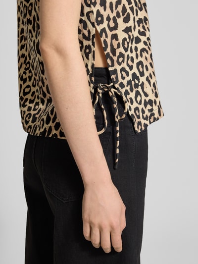 Frauenmodel trägt Blusentop aus Viskose-Mix mit seitlicher Schnürung von Vila im Leopardenmuster, Regular-Fit, Nahaufnahme Oberkörper. Modell 'PRISILLA' mit Rundhalsausschnitt, Rückenlänge bei Größe 36: 48 cm.
