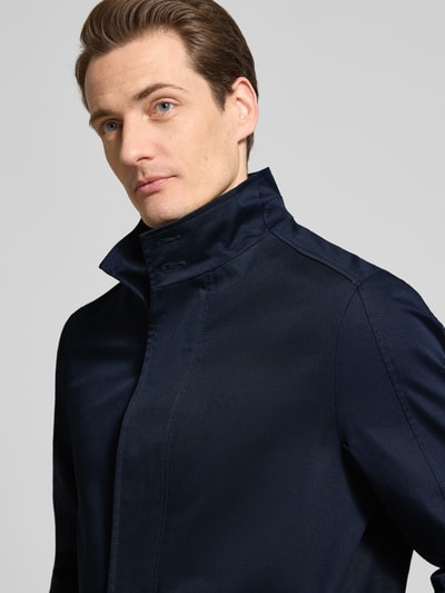 Männermodel trägt Regular Fit Mantel mit Stehkragen von MCNEAL aus Baumwoll-Mix, dunkelblau, Nahaufnahme Oberkörper, Eingrifftaschen, Größe M.