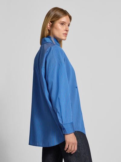 Vrouwenmodel draagt Bluse mit Bindedetails in Royalblau van Style Icon Collection, oversized overhemdblouse, mix van viscose en lyocell, overhemdkraag, doorlopende knoopsluiting, verlaagde schouders, 1-knoopsmachetten, ruglengte maat S 79 cm, mouwlengte maat S 50 cm, koningsblauw met fijne streepjes, zijdeachtig gladde textuur, Ganzkörperansicht Rückansicht.