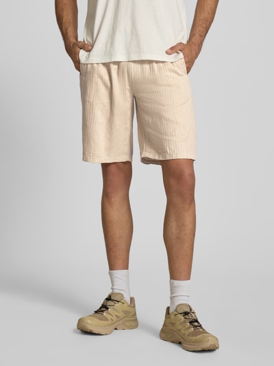 Männermodel trägt Shorts aus Leinen-Mix mit Eingrifftaschen Modell 'MARCO' von Blend in Beige, elastischer Bund, Straight Fit, Nahaufnahme Oberschenkel, Kontext: Herren Shorts mit Baumwoll-Anteil, Kordelzug, Seitentaschen, Gesäßleistentaschen, Größe M Maße