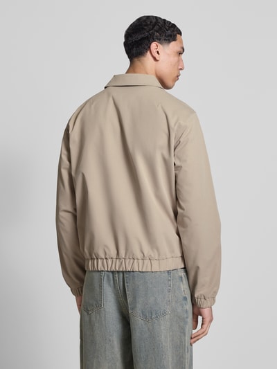 Männermodel trägt Jacke mit Zweiwege-Reißverschluss Modell 'CATSKILLS' von Jack & Jones in Beige, regelmäßiger Schnitt, Ganzkörperansicht Rückansicht. Rückenlänge 64 cm, Schulterbreite 49 cm, Brustweite 59 cm, Ärmellänge 66 cm, Label-Stitching, glatte Textur.