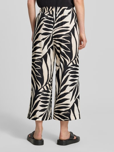 Frauenmodel trägt Wide Fit Stoffhose aus Viskose-Mix Modell 'Life' von Mango mit floraler Allover-Print, Ganzkörperansicht Rückansicht. Damen Stoffhose, Viskose-Mix, Wide-Fit, Modell 'Life', Verkürzte Passform, Elastischer Bund, Bundweite Größe S: 37 cm, Innenbeinlänge Größe S: 60 cm.