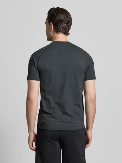 Męski model ma na sobie Regular Fit T-Shirt mit Rundhalsausschnitt od Fabletics, ciemnoszary kolor, krój regular fit, krótki rękaw, nadruk z logo, długość tyłu w rozmiarze M: 69 cm, widok całej sylwetki z tyłu.