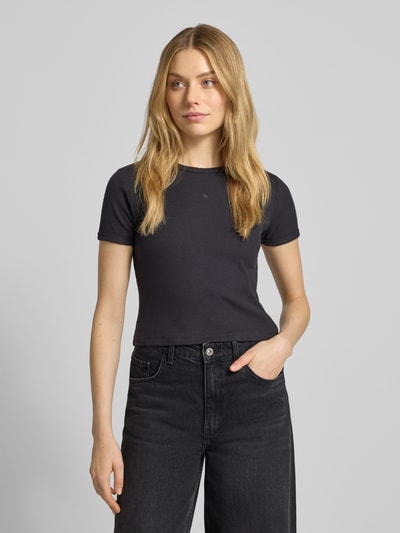 Frauenmodel trägt Cropped T-Shirt mit geripptem Rundhalsausschnitt von Scotch & Soda, Baumwoll-Elasthan-Mix, Slim Fit, Schwarz, Ganzkörperansicht von vorne.
