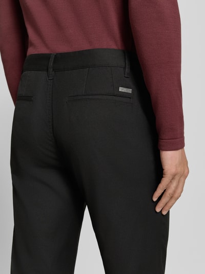 Männermodel trägt czarne Straight Fit Hose mit Viskose-Anteil von Armani Exchange, elastyczna mieszanka materiałów, wpuszczane kieszenie, z tyłu kieszenie, zapięcie na guzik i zamek błyskawiczny, Szerokość w rozmiarze 32/32: 44 cm, Długość wewnętrzna nogawki w rozmiarze 32/32: 84 cm, Ganzkörperansicht Rückansicht