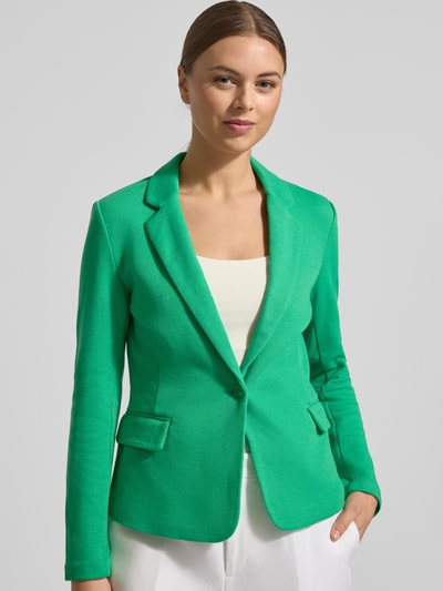 Kobiece modelka nosi Regular Fit Kurzblazer mit Baumwoll-Anteil Modell 'JULIA' von Vero Moda, efekt: jednolity kolor, kołnierz z połami, zapięcie na 1 guzik, długi rękaw, nachodzące na siebie guziki, kieszenie z patką, wykończenie materiału: pika; całkowite ujęcie sylwetki od przodu.