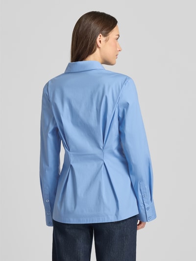 Frauenmodel trägt hellblaue Hemdbluse aus Baumwoll-Mix Modell 'Zopy' von Gestuz mit Hemdblusenkragen, Sportmanschetten, taillierter Passform, Langärmelig, durchgängiger Knopfleiste, Rückenlänge 68 cm bei Größe 36, strukturierte glatte Oberfläche, Ganzkörperansicht Rückansicht.