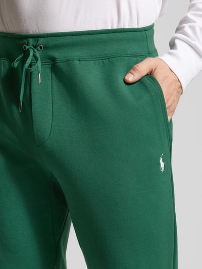 Männermodel trägt Tapered Sweatshorts aus Baumwoll-Mix von Polo Ralph Lauren in Optik: Unifarben mit Logo-Stitching, Nahaufnahme Oberkörper.