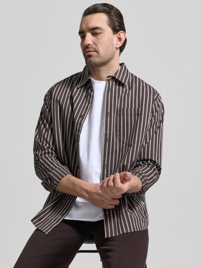 Männermodel trägt Regular Fit T-Shirt aus reiner Baumwolle von MCNEAL in Weiß unter braun-weiß gestreiftem Hemd, Nahaufnahme Oberkörper. Herren T-Shirt, Rundhalsausschnitt, kurzärmelig, Rückenlänge bei Größe M 66 cm.