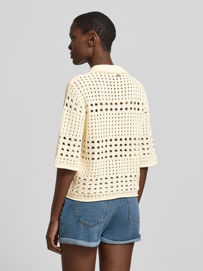 Frauenmodel trägt Regular Fit Bluse in Strick-Optik mit floralem Ziersteinbesatz von Liu Jo White aus Reine Baumwolle, Lochmuster, Halbarm, Umlegekragen, durchgehende Knopfleiste, Rückenlänge 45 cm, Ärmellänge 34 cm, helle und blaue Farbtöne, strukturierte Oberfläche, Ganzkörperansicht Rückansicht.