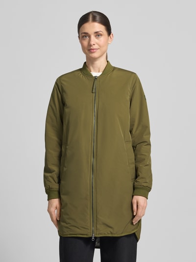 Frauenmodel trägt Jacke mit Zweiwege-Reißverschluss von camel active in Olivgrün, lockere Passform, Stehkragen, extralang, Ganzkörperansicht von vorne.