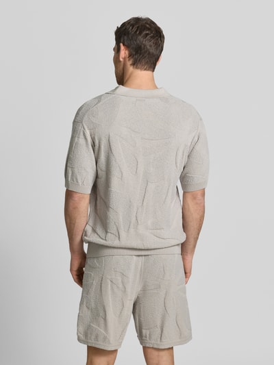 Männermodel trägt Relaxed Fit Poloshirt aus reiner Baumwolle Modell 'ASURFO' von BOSS Orange in Optik: Unifarben, Struktur, Ganzkörperansicht Rückansicht.