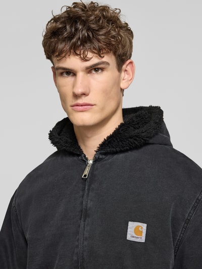 Männermodel trägt Jacke mit Zweiwege-Reißverschluss Modell 'MITCH' von Carhartt Work In Progress in Schwarz, reine Baumwolle, Nahaufnahme Oberkörper.